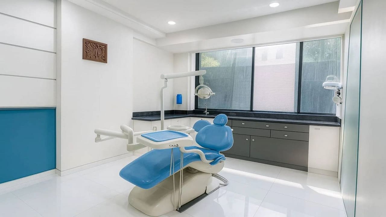 Treatment room with a blue dental chair at Trisa Dental Solutions