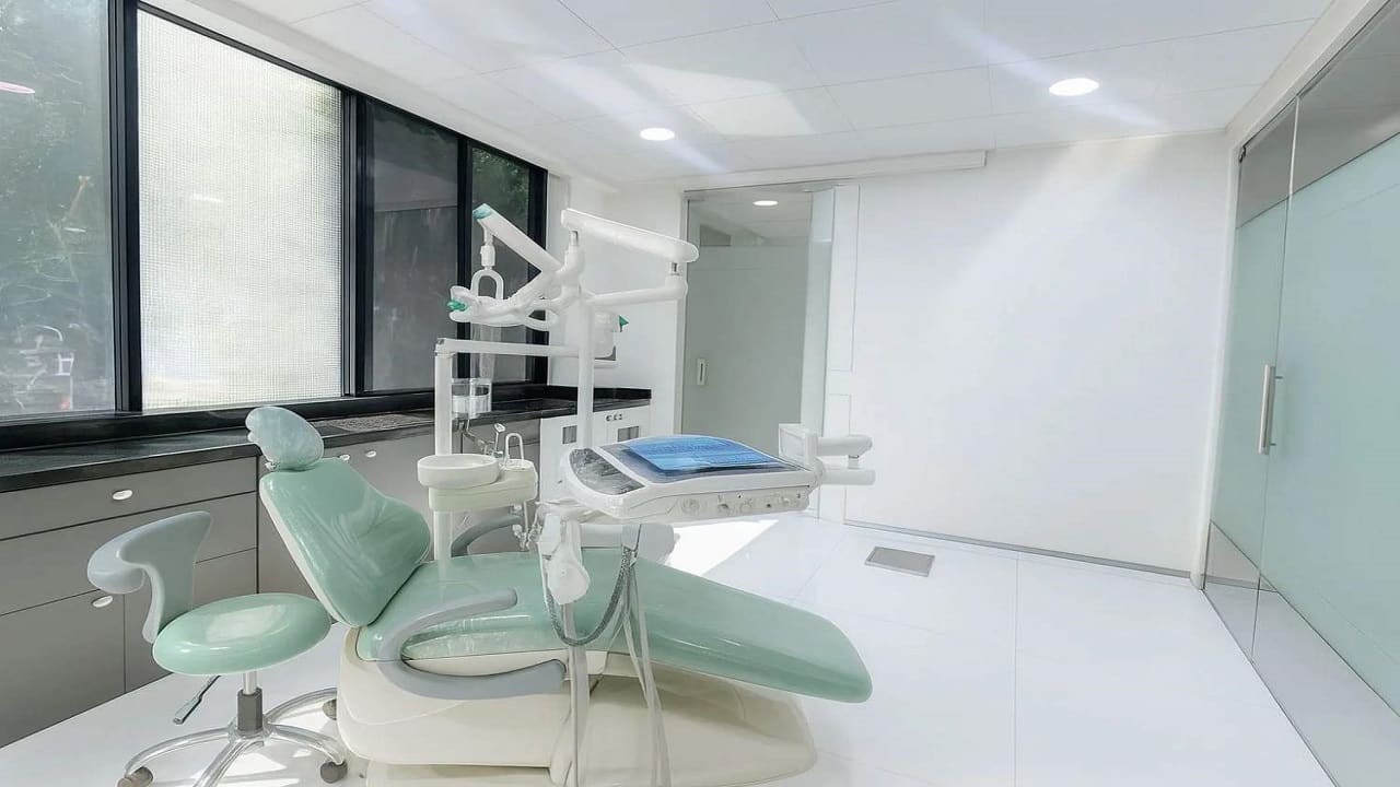 Treatment room with a mint green dental chair beside the window