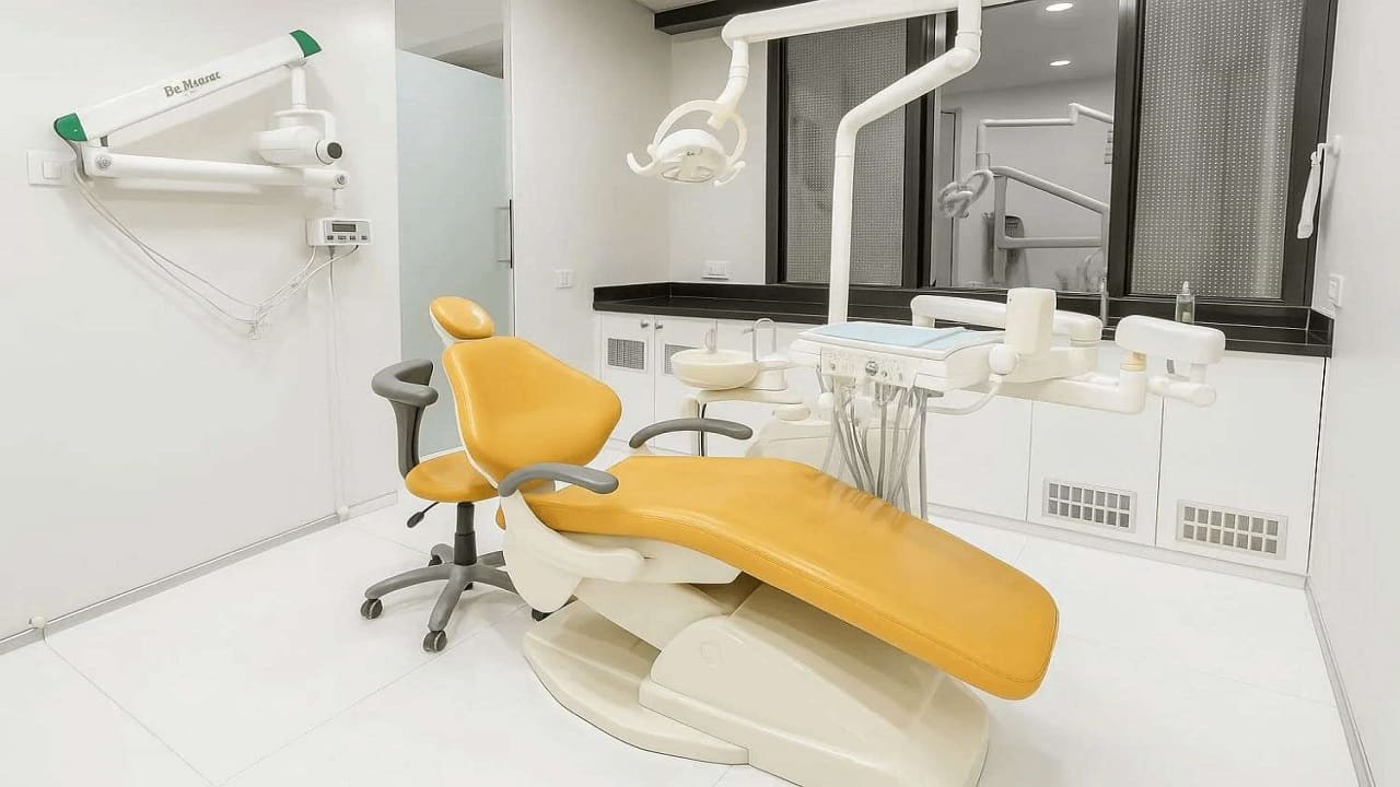 Treatment room with a yellow dental chair at Trisa Dental Solutions