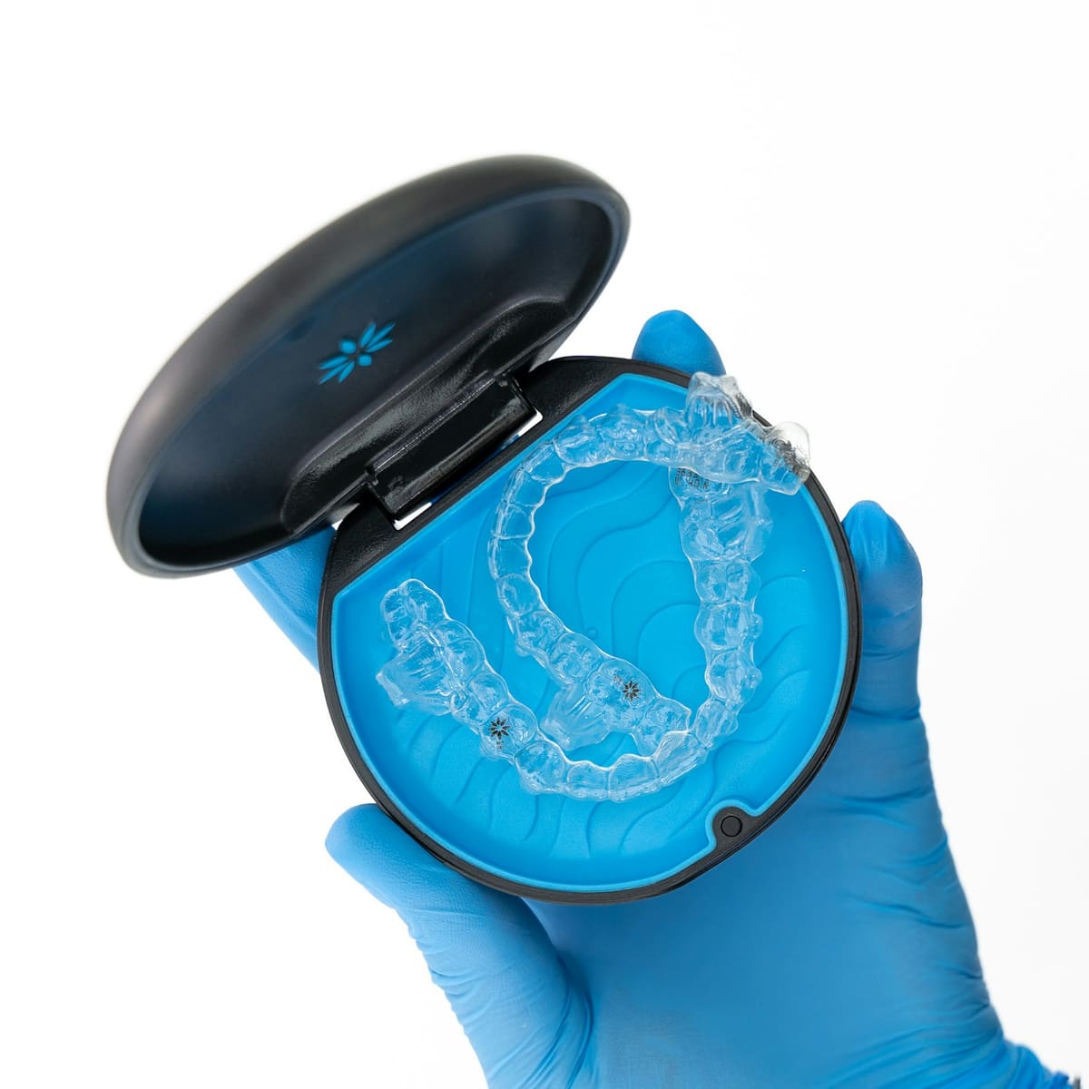 A clear aligner in its open case